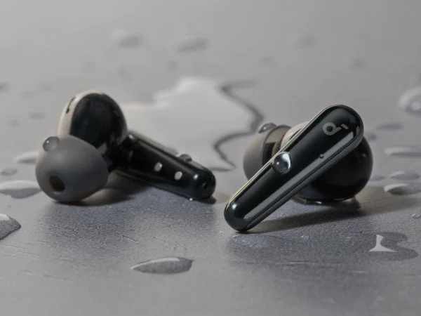 水滴が落ちたグレーの床の上に置かれた、ブラックのSoundcore Liberty 5のイヤホン本体を写したAnker公式の画像